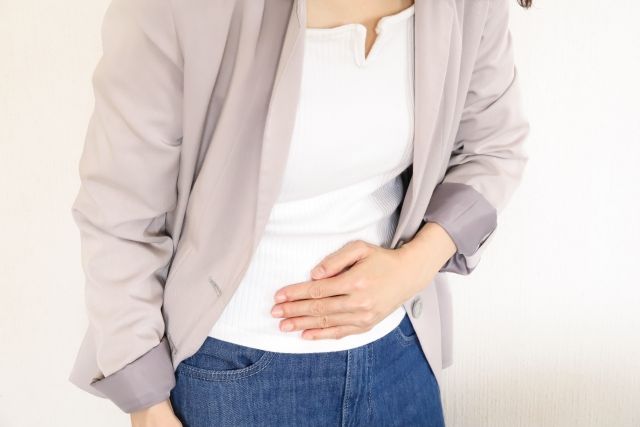 お腹を手で抑える女性